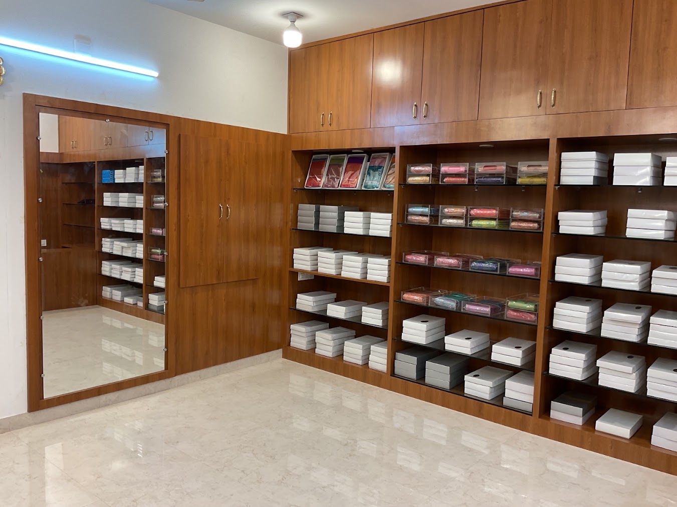Sri Iniya Silks store interior with wooden shelves of neatly boxed silk sarees